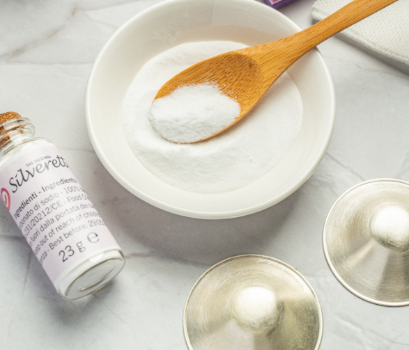 Baking soda cleaning paste in a bowl beside Silverette silver nursing cups ready to clean